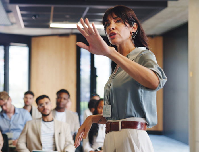 A professional confidently communicates with an attentive audience.