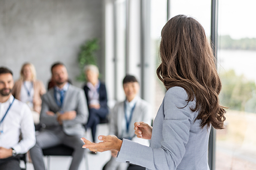 A professional confidently communicates with an attentive audience, creating a dynamic environment for collaboration and professional growth.
